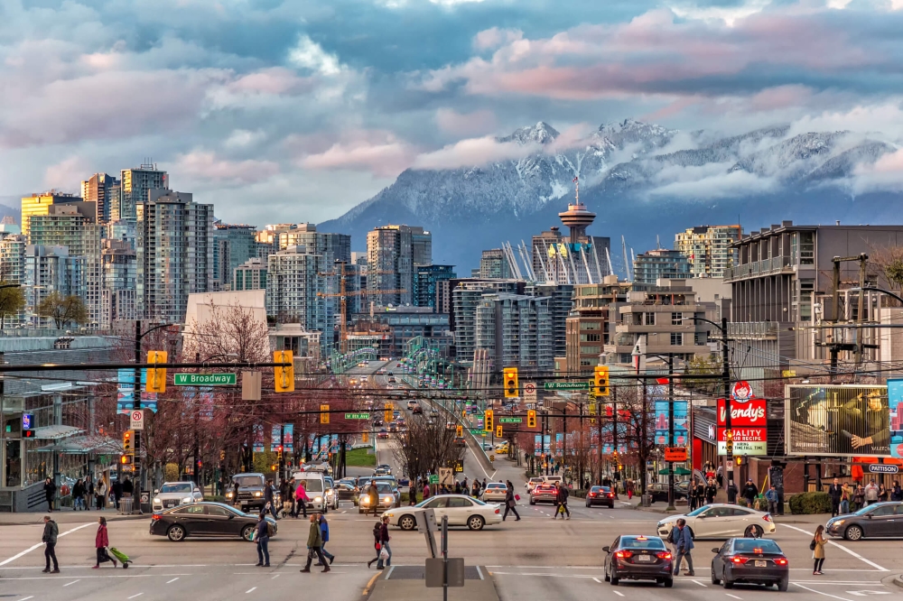 A busy street in Vancouver, BC with mountains in the background