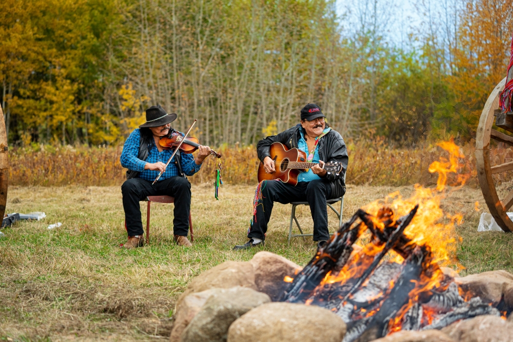 Two fiddlers by a fire