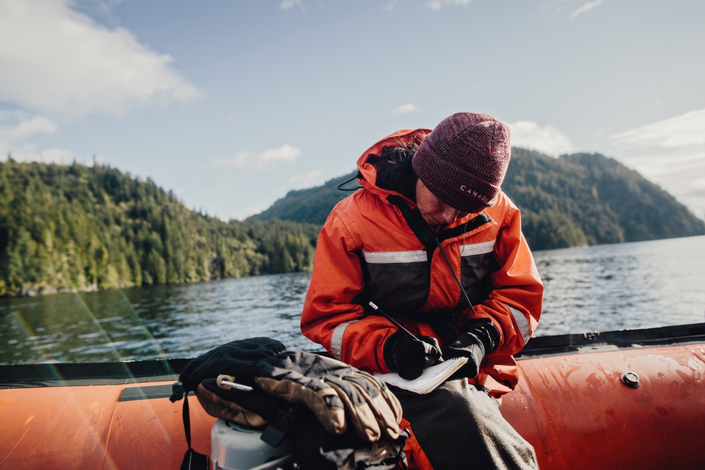 Person in boat writing field notes